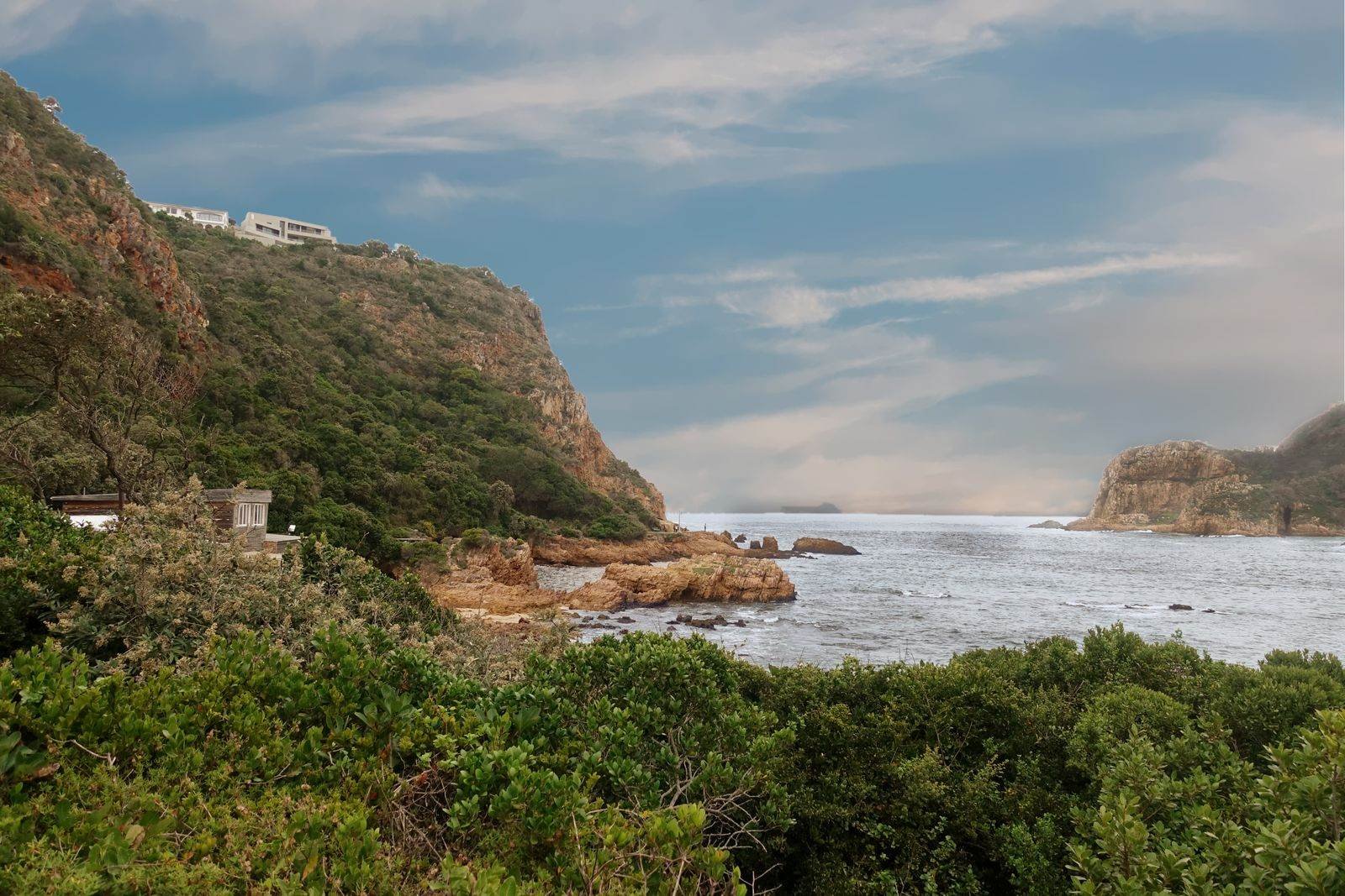 Forested cliffs meeting the sea near Knysna on the Garden Route