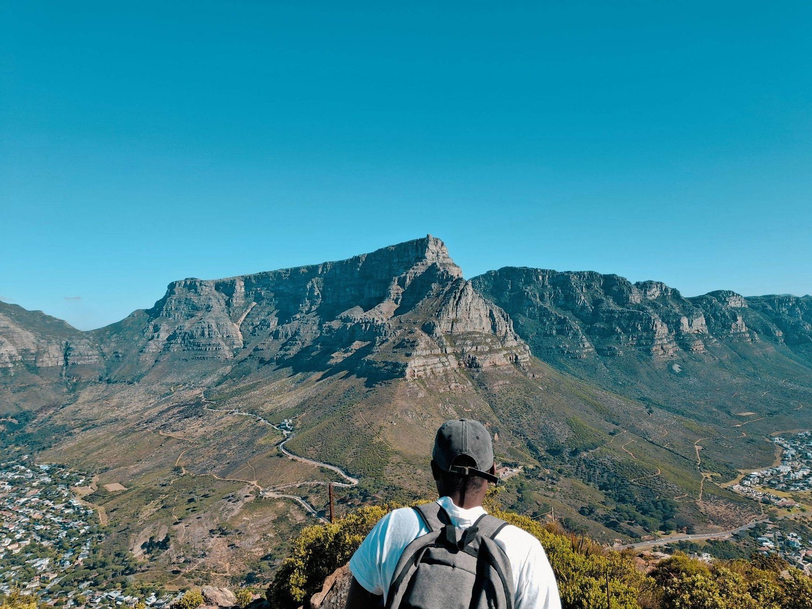A hiker looking out over Table Mountain from Lion's Head, Cape Town